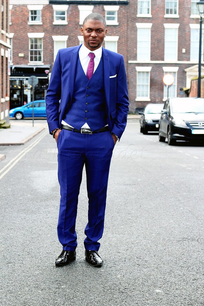 Men’s blue three piece suit, pocket square & purple neck tie